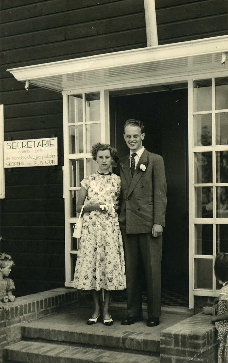 Dirk Kuik en zijn Corrie voor het gemeentehuis (openbaar lichaam) in Emmeloord op de dag dat zijn zus trouwde, circa 1953