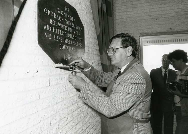 Gedeputeerde Pieter Loos metselt een gedenksteen in de 2.500ste woning van project Sluisblok in Almere-Haven, mei 1987