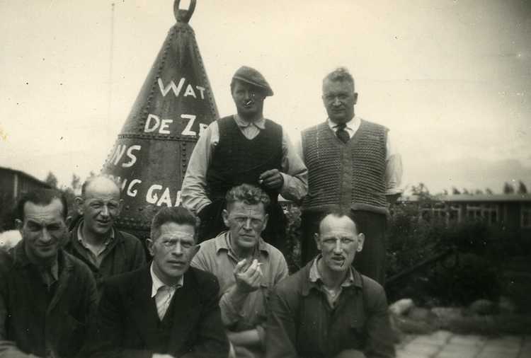 De corveeërs van kamp Schokland op de foto voor de boei met kampbeheerder Appels (staand, rechts) en kok Vis (zittend, links), ca. 1955 (privécollectie familie Appels)