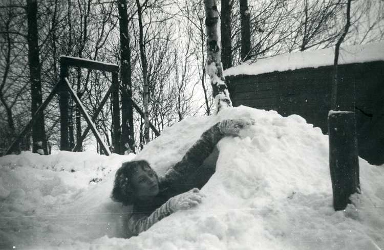 Winter in kamp Schokland. Lien maakt een sneeuwhut, waar ze dan in gingen zitten met een kaarsje en wat lekkers, ca. 1955 (privécollectie familie Appels)