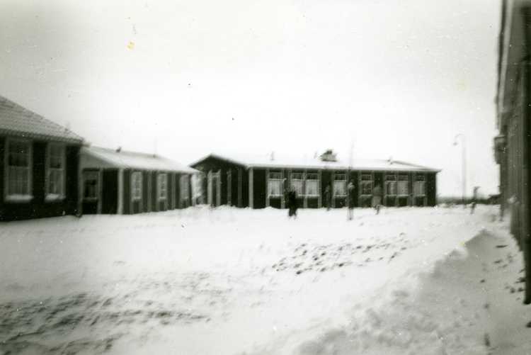 Het werkeiland: de ziekenbarak (links), woonhuis familie Flobbe (midden), woonhuizen familie De Vries en Schuil (rechts). Foto is genomen vanaf de hoek van kapper Borst, winter 1954/1955