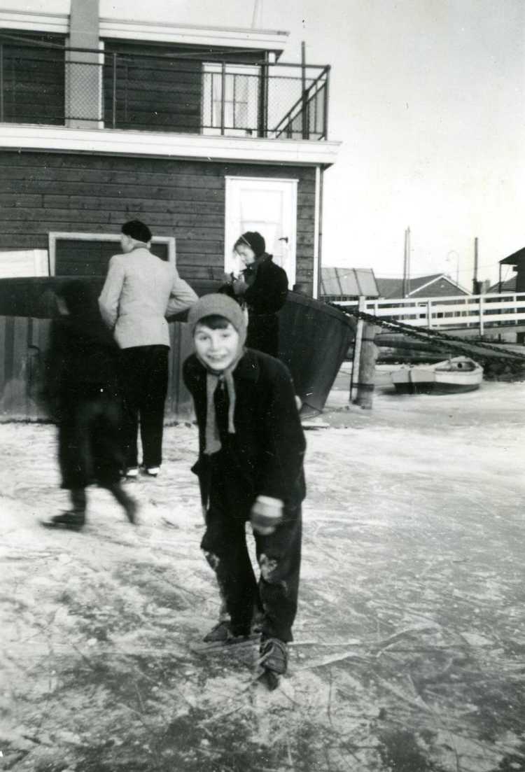 Bob Flobbe op het ijs in de haven. Op de achtergrond de Bever-ark van de familie Van der Meulen, januari 1956
