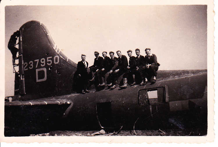 Marinus Nieuwenhuize (met pet op) poseert samen met andere polderwerkers bij een neergestorte geallieerde bommenwerper, 1943/1944 (privécollectie Gerard Nieuwenhuize)