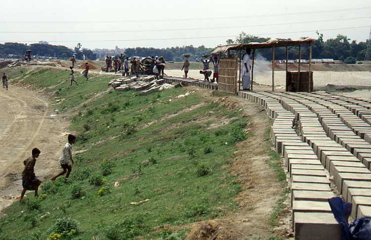De dijk rond Dhaka in aanleg aan de rivierkant